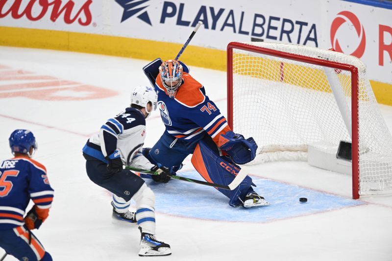 Mar 20, 2025; Edmonton, Alberta, CAN; Winnipeg Jets defenceman Josh Morrissey (44) goes in on Edmonton Oilers goalie Stuart Skinner (74) during the second period at Rogers Place. Mandatory Credit: Walter Tychnowicz-Imagn Images