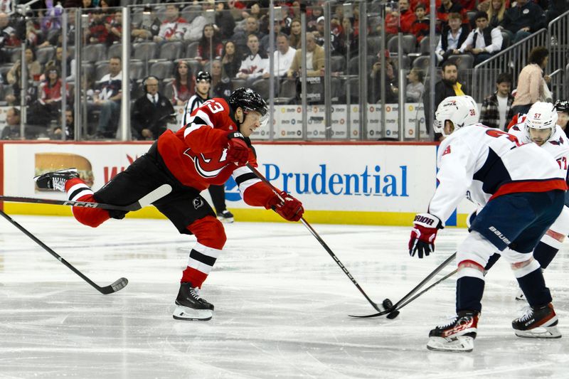 Oct 19, 2024; Newark, New Jersey, USA; New Jersey Devils left wing Jesper Bratt (63) takes a shot as Washington Capitals defenseman Rasmus Sandin (38) defends during the second period at Prudential Center. Mandatory Credit: John Jones-Imagn Images