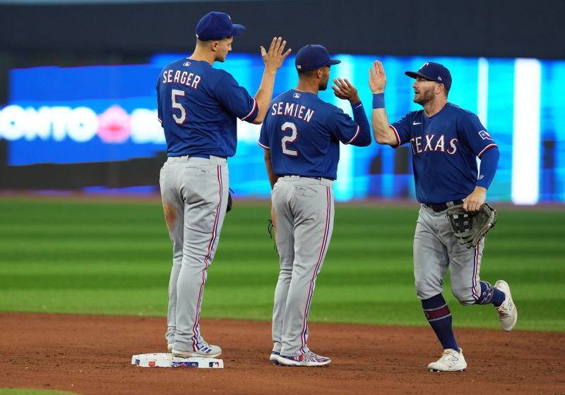 Sep 13, 2023; Toronto, Ontario, CAN; Texas Rangers right fielder Robbie Grossman (4) celebrates the win with second baseman Marcus Semien (2) against the Toronto Blue Jays at the end of the ninth inning at Rogers Centre. Mandatory Credit: Nick Turchiaro-USA TODAY Sports