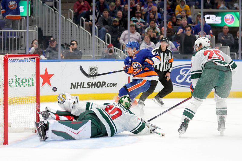 Nov 7, 2025; Elmont, New York, USA; New York Islanders center Jean-Gabriel Pageau (44) scores a goal against Minnesota Wild goaltender Jesper Wallstedt (30) and defenseman Jonas Brodin (25) during the second period at UBS Arena. Mandatory Credit: Brad Penner-Imagn Images