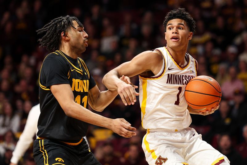 Jan 6, 2026; Minneapolis, Minnesota, USA; Minnesota Golden Gophers guard Isaac Asuma (1) works around Iowa Hawkeyes guard Kael Combs (11) during the first half at Williams Arena. Mandatory Credit: Matt Krohn-Imagn Images