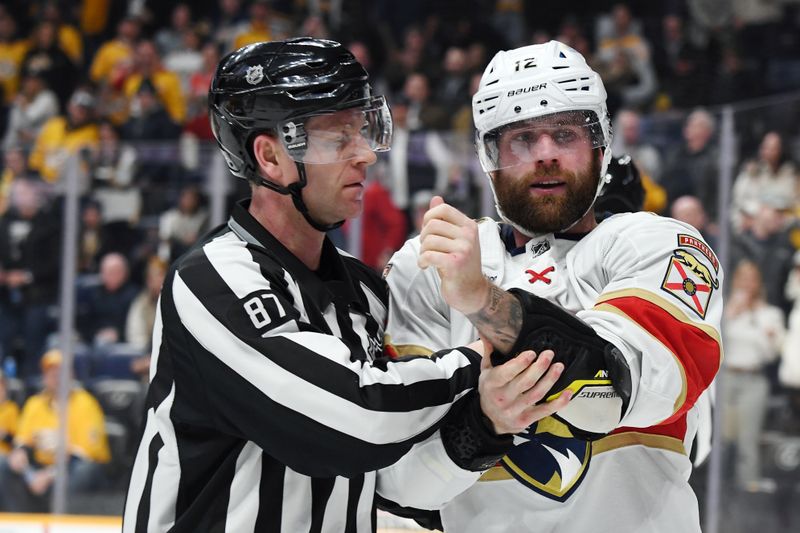 Jan 22, 2024; Nashville, Tennessee, USA; Florida Panthers left wing Jonah Gadjovich (12) is taken to the penalty box by linesman Devin Berg (87) after a fight during the second period against the Nashville Predators at Bridgestone Arena. Mandatory Credit: Christopher Hanewinckel-USA TODAY Sports