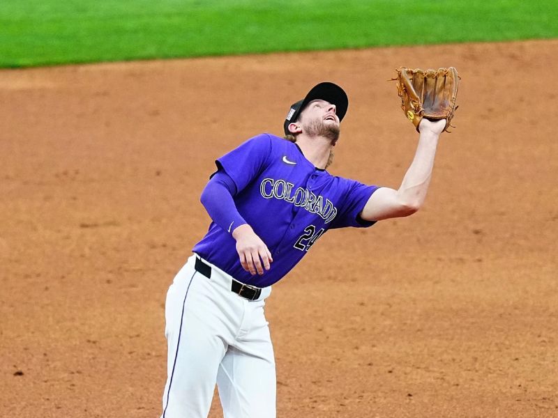 Jul 19, 2024; Denver, Colorado, USA; Colorado Rockies third base Ryan McMahon (24) fields the ball in the second inning against the San Francisco Giants at Coors Field. Mandatory Credit: Ron Chenoy-USA TODAY Sports