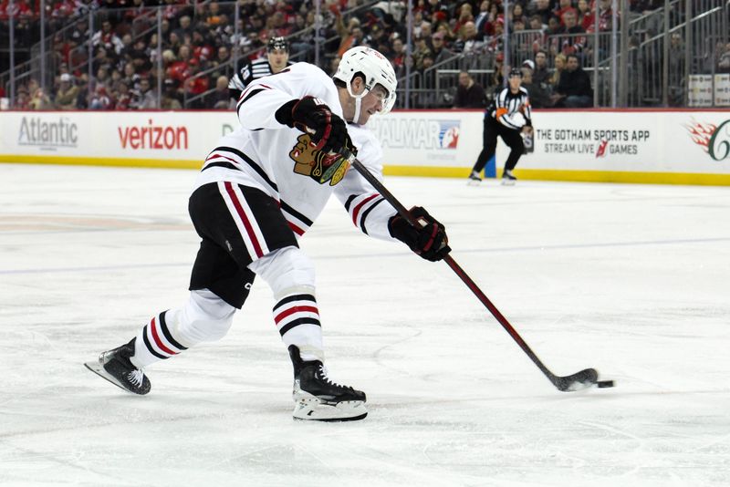 Dec 14, 2024; Newark, New Jersey, USA; Chicago Blackhawks center Ryan Donato (8) shoots the puck against the New Jersey Devils during the third period at Prudential Center. Mandatory Credit: John Jones-Imagn Images
