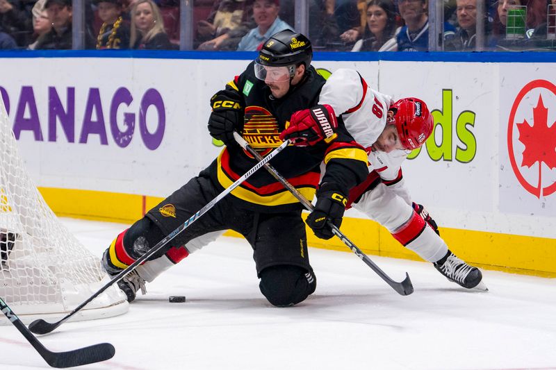 Oct 28, 2024; Vancouver, British Columbia, CAN; Vancouver Canucks forward J.T. Miller (9) battles with Carolina Hurricanes forward Jordan Martinook (48) during the first period at Rogers Arena. Mandatory Credit: Bob Frid-Imagn Images