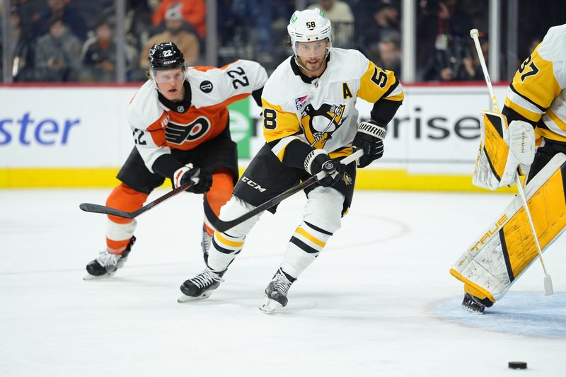 Oct 28, 2025; Philadelphia, Pennsylvania, USA; Pittsburgh Penguins defenseman Kris Letang (58) chases the puck against Philadelphia Flyers center Christian Dvorak (22) in the first period at Xfinity Mobile Arena. Mandatory Credit: Kyle Ross-Imagn Images