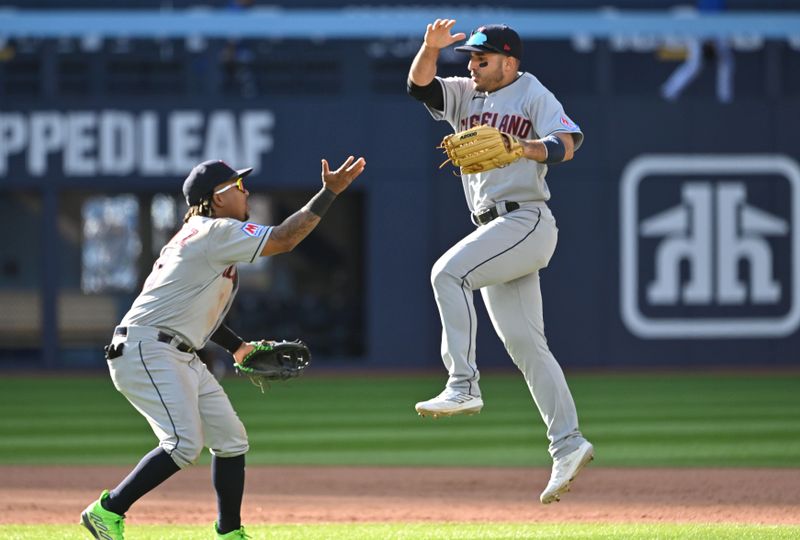 Aug 27, 2023; Toronto, Ontario, CAN;  Cleveland Indians right fielder Ramon Laureano (10) leaps as he is greeted by third baseman Jose Ramirez (11) as they celebrate a win over the Toronto Blue Jays at Rogers Centre. Mandatory Credit: Dan Hamilton-USA TODAY Sports