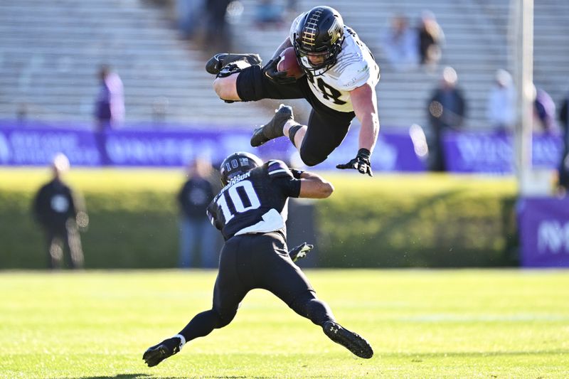 Nov 18, 2023; Evanston, Illinois, USA;  Purdue Boilermakers tight end Garrett Miller (88) leaps over Northwestern Wildcats defensive back Theran Johnson (10) after catching a pass in the fourth quarter at Ryan Field. Mandatory Credit: Jamie Sabau-USA TODAY Sports