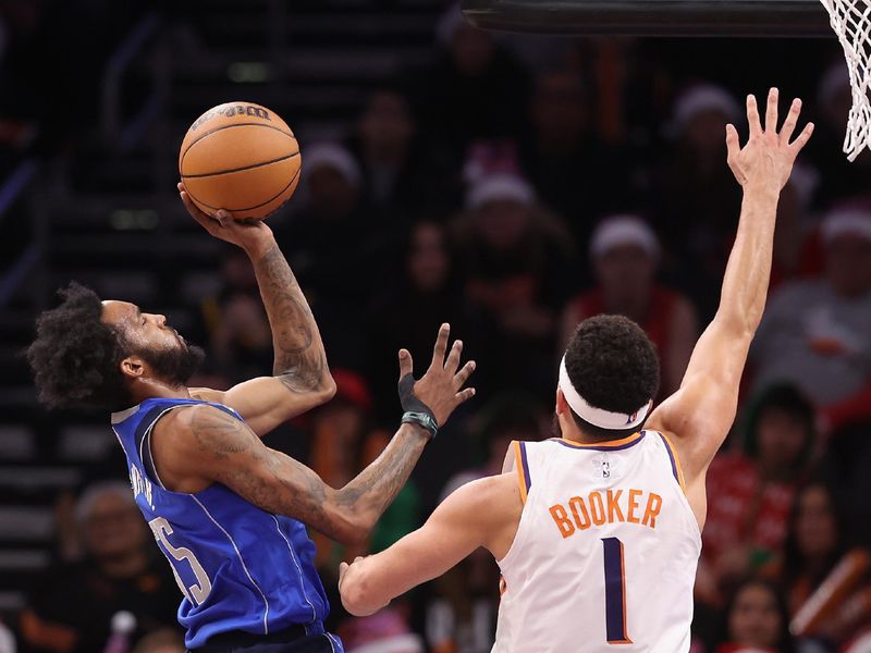 PHOENIX, ARIZONA - DECEMBER 25: Derrick Jones Jr. #55 of the Dallas Mavericks attempts a shot over Devin Booker #1 of the Phoenix Suns during the second half of the NBA game at Footprint Center on December 25, 2023 in Phoenix, Arizona. The Mavericks defeated the Suns 128-114. NOTE TO USER: User expressly acknowledges and agrees that, by downloading and or using this photograph, User is consenting to the terms and conditions of the Getty Images License Agreement.  (Photo by Christian Petersen/Getty Images)