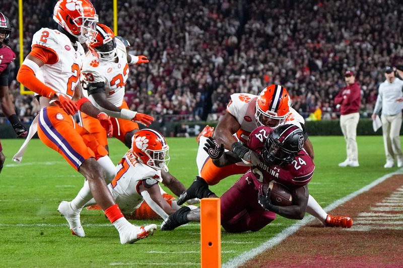 Nov 25, 2023; Columbia, South Carolina, USA; South Carolina Gamecocks running back Mario Anderson (24) is run out of bounds by Clemson Tigers linebacker Jeremiah Trotter Jr. (54) in the first half at Williams-Brice Stadium. Mandatory Credit: David Yeazell-USA TODAY Sports