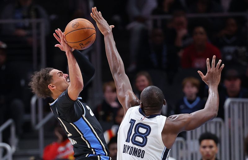 ATLANTA, GEORGIA - DECEMBER 23:  Trae Young #11 of the Atlanta Hawks is defended by Bismack Biyombo #18 of the Memphis Grizzlies during the fourth quarter at State Farm Arena on December 23, 2023 in Atlanta, Georgia.  NOTE TO USER: User expressly acknowledges and agrees that, by downloading and/or using this photograph, user is consenting to the terms and conditions of the Getty Images License Agreement. (Photo by Kevin C. Cox/Getty Images)