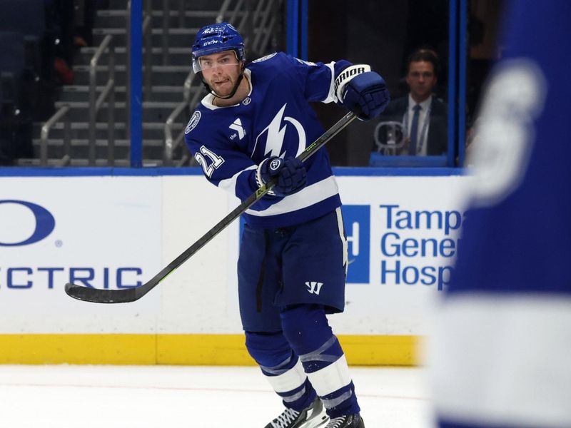 Sep 26, 2025; Tampa, Florida, USA; Tampa Bay Lightning center Brayden Point (21) passes the puck against the Carolina Hurricanes during the third period at Benchmark International Arena. Mandatory Credit: Kim Klement Neitzel-Imagn Images