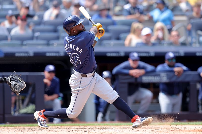 Jul 20, 2024; Bronx, New York, USA; Tampa Bay Rays left fielder Randy Arozarena (56) follows through on a two run home run against the New York Yankees during the seventh inning at Yankee Stadium. Mandatory Credit: Brad Penner-USA TODAY Sports