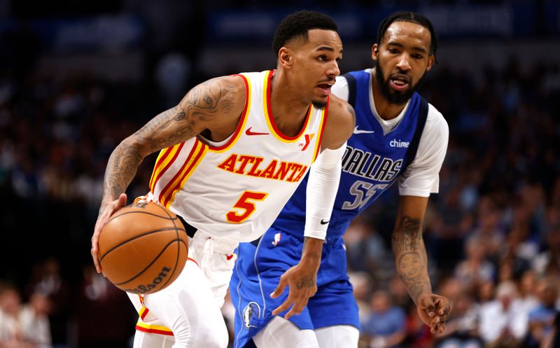 DALLAS, TX - APRIL 04: Dejounte Murray #5 of the Atlanta Hawks handles the ball as Derrick Jones Jr. #55 of the Dallas Mavericks defends in the first half at American Airlines Center on April 4, 2024 in Dallas, Texas. NOTE TO USER: User expressly acknowledges and agrees that, by downloading and or using this photograph, User is consenting to the terms and conditions of the Getty Images License Agreement. (Photo by Ron Jenkins/Getty Images)