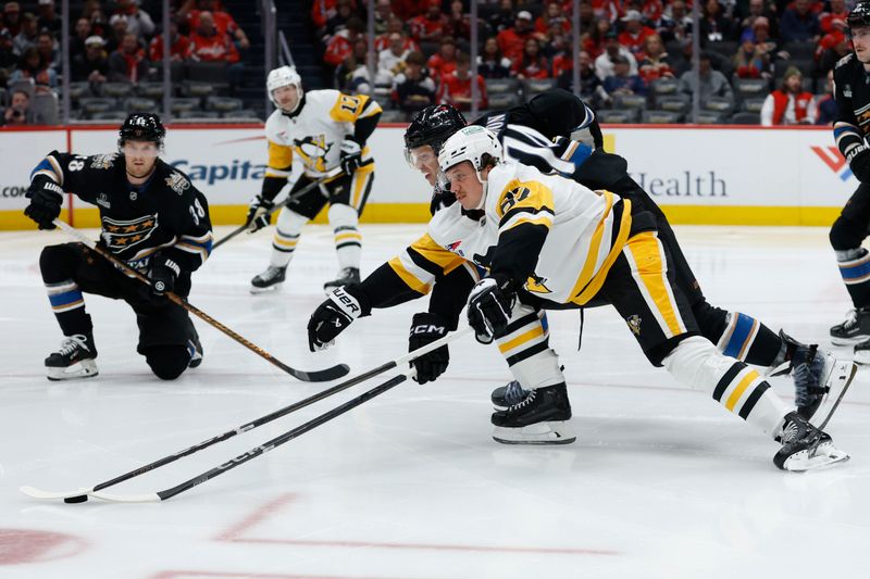 Jan 18, 2025; Washington, District of Columbia, USA; Pittsburgh Penguins right wing Rickard Rakell (67) and Washington Capitals defenseman John Carlson (74) battle for the puck in the second period at Capital One Arena. Mandatory Credit: Geoff Burke-Imagn Images