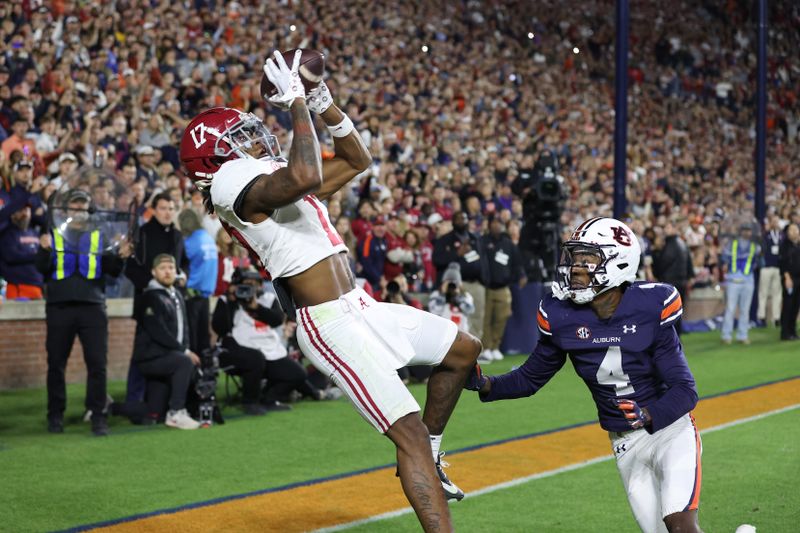 Nov 25, 2023; Auburn, Alabama, USA;  Alabama Crimson Tide wide receiver Isaiah Bond (17) scores the game winning touchdown over Auburn Tigers cornerback D.J. James (4) during the fourth quarter at Jordan-Hare Stadium. Mandatory Credit: John Reed-USA TODAY Sports