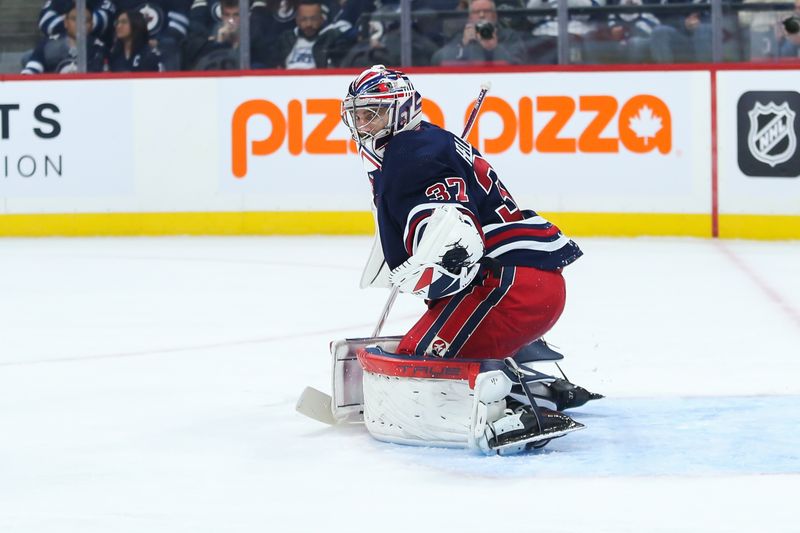 Jan 26, 2023; Winnipeg, Manitoba, CAN;  Winnipeg Jets goalie Connor Hellebuyck (37) makes a save on a Buffalo Sabres shot during the first period at Canada Life Centre. Mandatory Credit: Terrence Lee-USA TODAY Sports