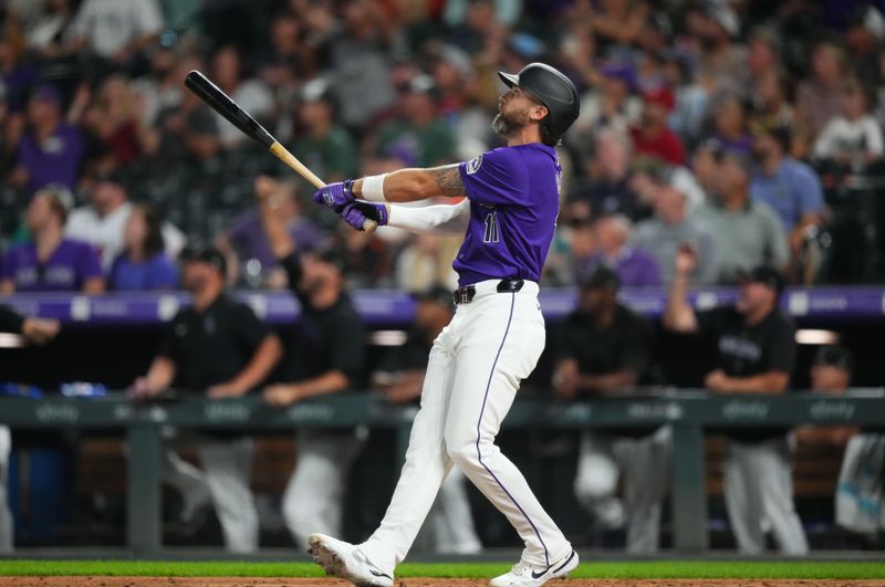 Jul 19, 2024; Denver, Colorado, USA; Colorado Rockies outfielder Jake Cave (11) hits a three run home run in the eighth inning against the San Francisco Giants at Coors Field. Mandatory Credit: Ron Chenoy-USA TODAY Sports