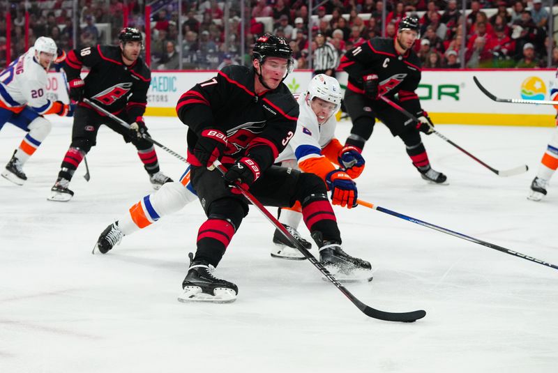 Apr 20, 2024; Raleigh, North Carolina, USA; Carolina Hurricanes right wing Andrei Svechnikov (37) skates with the puck outside New York Islanders defenseman Mike Reilly (2) during the first period in game one of the first round of the 2024 Stanley Cup Playoffs at PNC Arena. Mandatory Credit: James Guillory-USA TODAY Sports