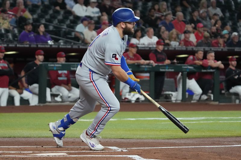 Sep 3, 2025; Phoenix, Arizona, USA; Texas Rangers first base Jake Burger (21) hits a single against the Arizona Diamondbacks in the first inning at Chase Field. Mandatory Credit: Rick Scuteri-Imagn Images