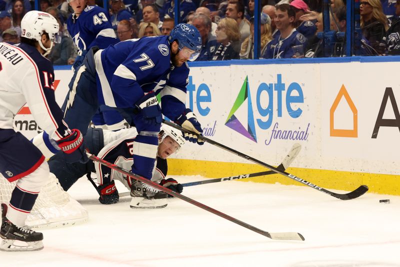 Apr 9, 2024; Tampa, Florida, USA; Tampa Bay Lightning defenseman Victor Hedman (77) defends the puck as congratulated10 and Columbus Blue Jackets left wing Johnny Gaudreau (13) fight for the puck during the second period at Amalie Arena. Mandatory Credit: Kim Klement Neitzel-USA TODAY Sports