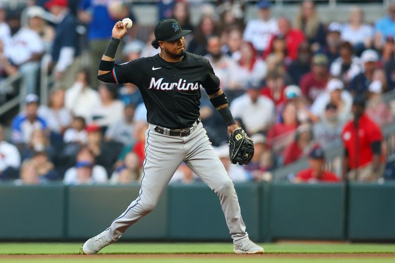 Apr 24, 2024; Atlanta, Georgia, USA; Miami Marlins second baseman Luis Arraez (3) throws a runner out at first against the Atlanta Braves in the first inning at Truist Park. Mandatory Credit: Brett Davis-USA TODAY Sports