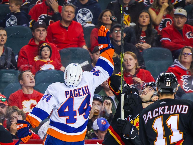 Nov 18, 2023; Calgary, Alberta, CAN; New York Islanders center Jean-Gabriel Pageau (44) and Calgary Flames defenseman Nick DeSimone (57) battle for the puck during the second period at Scotiabank Saddledome. Mandatory Credit: Sergei Belski-USA TODAY Sports