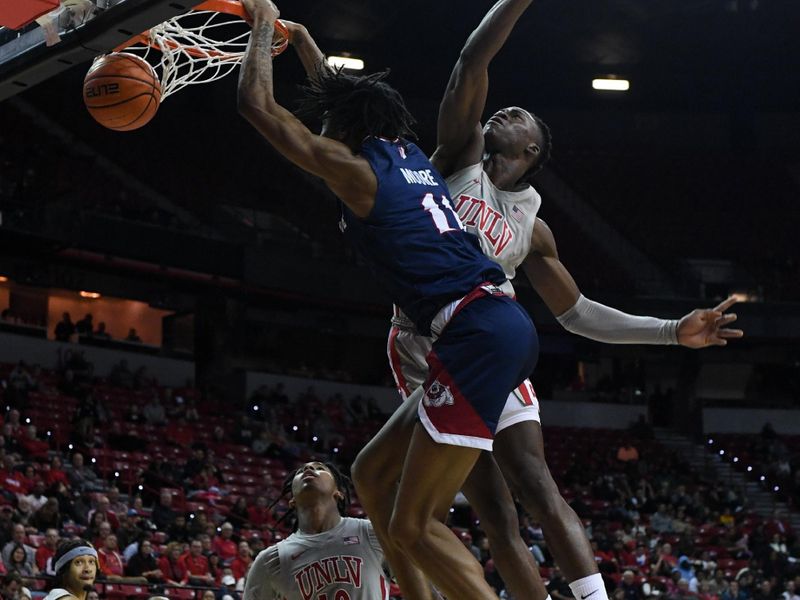 Feb 3, 2023; Las Vegas, Nevada, USA; Fresno State Bulldogs forward Isaih Moore (11) dunks on UNLV Runnin' Rebels guard Keshon Gilbert (10) and forward Victor Iwuakor (0) in the second half at Thomas & Mack Center. Mandatory Credit: Candice Ward-USA TODAY Sports