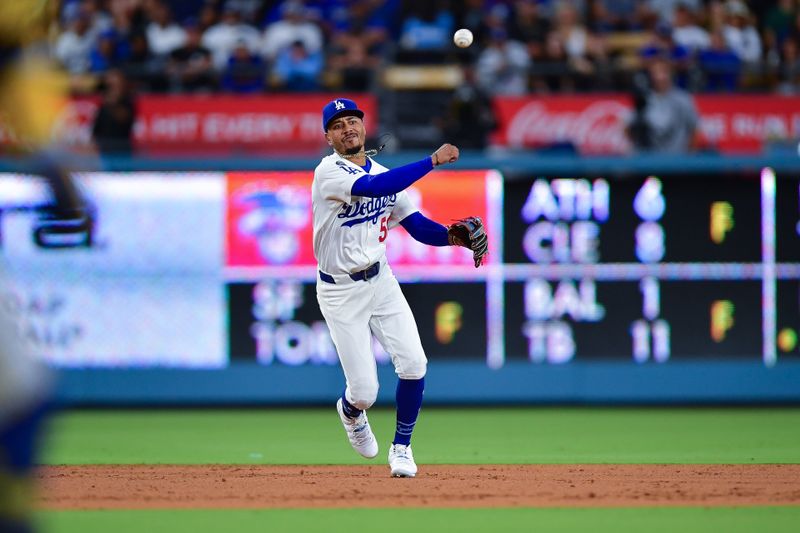 Jul 18, 2025; Los Angeles, California, USA; Los Angeles Dodgers shortstop Mookie Betts (50) throws to first for the out against Milwaukee Brewers catcher William Contreras (24) during the ninth inning at Dodger Stadium. Mandatory Credit: Gary A. Vasquez-Imagn Images
