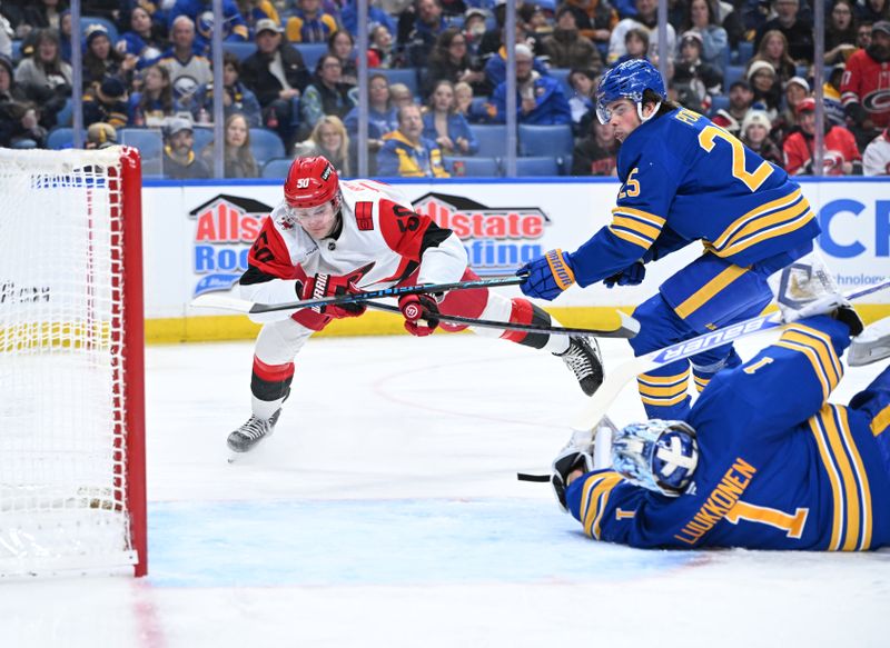 Nov 23, 2025; Buffalo, New York, USA; Carolina Hurricanes left wing Eric Robinson (50) dives on a shot attempt past Buffalo Sabres goaltender Ukko-Pekka Luukkonen (1) and defenseman Owen Power (25) in the first period at KeyBank Center. Mandatory Credit: Mark Konezny-Imagn Images
