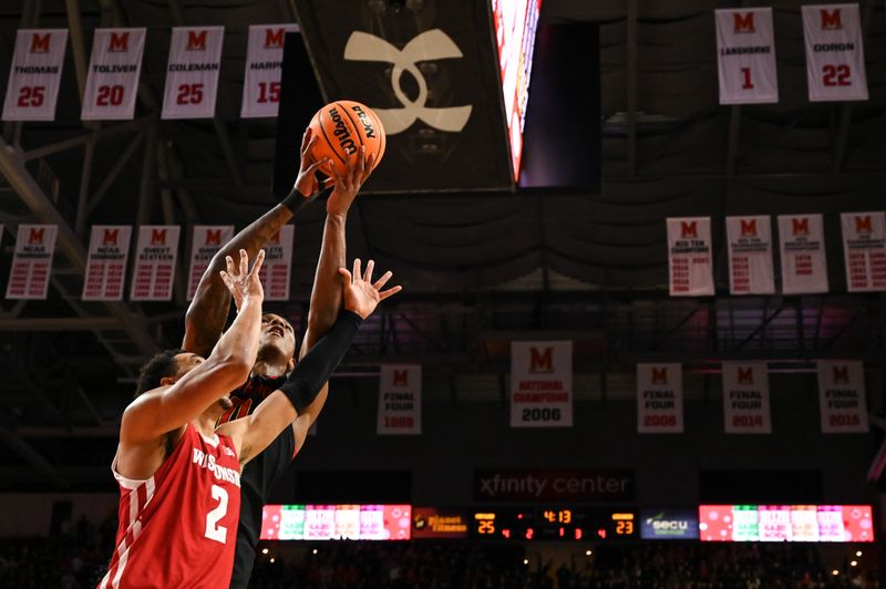 Jan 25, 2023; College Park, Maryland, USA;  Maryland Terrapins forward Julian Reese (10) leaps to grab a rebound over Wisconsin Badgers guard Jordan Davis (2) during the first half at Xfinity Center. Mandatory Credit: Tommy Gilligan-USA TODAY Sports