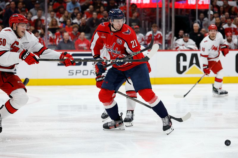 May 8, 2025; Washington, District of Columbia, USA; Washington Capitals center Aliaksei Protas (21) and Carolina Hurricanes left wing Eric Robinson (50) battle for the puck in the second period in game two of the second round of the 2025 Stanley Cup Playoffs at Capital One Arena. Mandatory Credit: Geoff Burke-Imagn Images