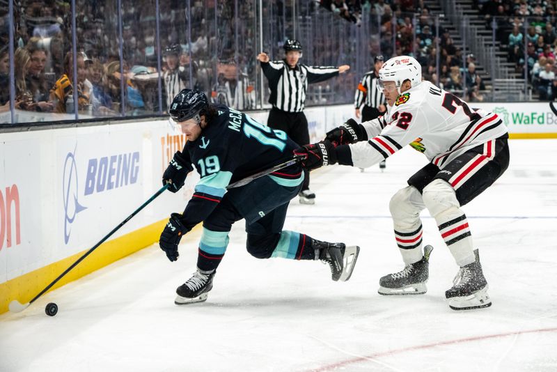 Nov 14, 2024; Seattle, Washington, USA;  Seattle Kraken forward Jared McCann (19) battles Chicago Blackhawks defenseman Alex Vlasic (72) for the puck during the third period at Climate Pledge Arena. Mandatory Credit: Stephen Brashear-Imagn Images