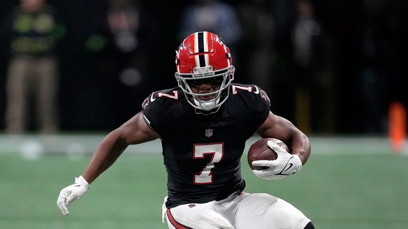 FILE - Atlanta Falcons running back Bijan Robinson (7) runs against the Washington Commanders during the first half of an NFL football game, Sunday, Oct. 15, 2023, in Atlanta. Falcons rookie running back Bijan Robinson's health will be closely watched this week after he was limited to only one carry after not feeling well before last week's game at Tampa. (AP Photo/John Bazemore, File)