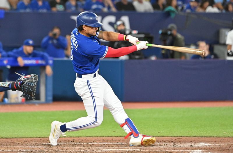 Sep 12, 2023; Toronto, Ontario, CAN;  Toronto Blue Jays third baseman Santiago Espinal (5) hits a double against the Texas Rangers in the seventh inning at Rogers Centre. Mandatory Credit: Dan Hamilton-USA TODAY Sports