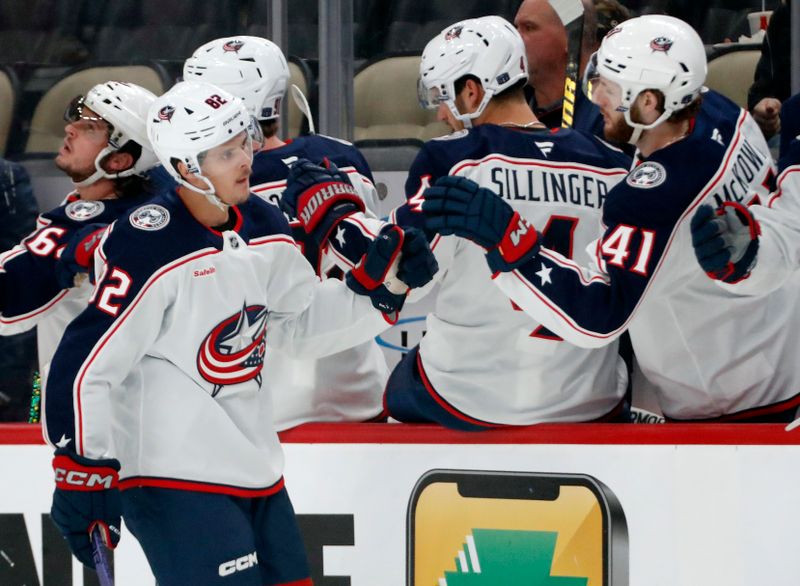 Oct 4, 2024; Pittsburgh, Pennsylvania, USA;  Columbus Blue Jackets left wing Mikael Pyyhtia (82) celebrates his goal with the Columbus Blue Jackets bench against the Pittsburgh Penguins during the first period at PPG Paints Arena. Mandatory Credit: Charles LeClaire-Imagn Images