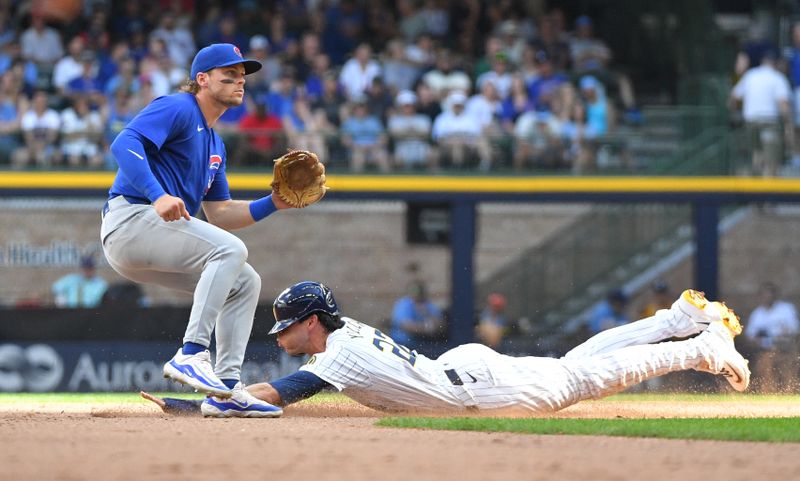 Jun 29, 2024; Milwaukee, Wisconsin, USA; Milwaukee Brewers outfielder Christian Yelich (22) steals second base in the eighth inning against the Chicago Cubs second baseman Nico Hoerner (2) at American Family Field. Mandatory Credit: Michael McLoone-USA TODAY Sports