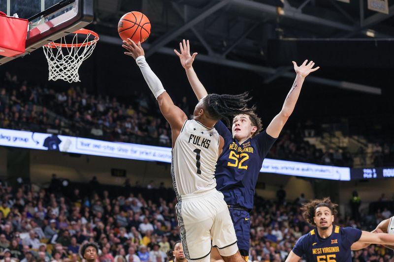 Feb 14, 2026; Orlando, Florida, USA; UCF Knights guard Themus Fulks (1) goes to the basket against West Virginia Mountaineers guard Treysen Eaglestaff (52) during the second half at Addition Financial Arena. Mandatory Credit: Mike Watters-Imagn Images
