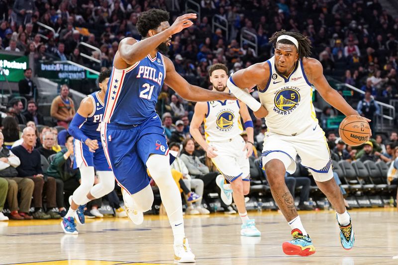 SAN FRANCISCO, CA - MARCH 24: Kevon Looney #5 of the Golden State Warriors drives to the basket in the third quarter against Joel Embiid #21 of the Philadelphia 76ers at Chase Center on March 24, 2023 in San Francisco, California. NOTE TO USER: User expressly acknowledges and agrees that, by downloading and/or using this photograph, User is consenting to the terms and conditions of the Getty Images License Agreement. (Photo by Kavin Mistry/Getty Images)