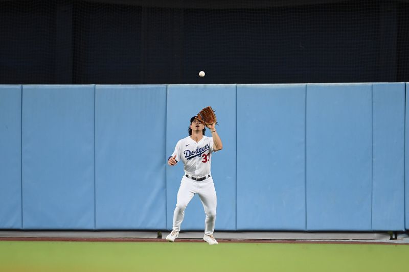 Aug 12, 2023; Los Angeles, California, USA; Los Angeles Dodgers center fielder James Outman (33) makes a catch against the Colorado Rockies during the sixth inning at Dodger Stadium. Mandatory Credit: Jonathan Hui-USA TODAY Sports