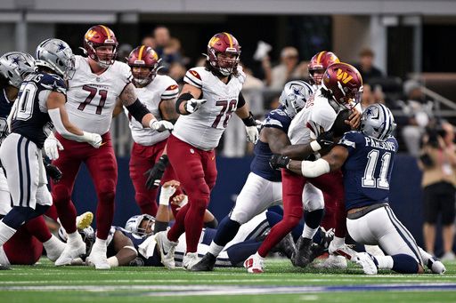 Washington Commanders quarterback Jayden Daniels (5) is tackled by Dallas Cowboys linebacker Micah Parsons (11) and defensive tackle Mazi Smith (58) as guard Andrew Wylie (71) and guard Sam Cosmi (76) look on during an NFL football game in Arlington, Texas, Sunday, Jan. 5, 2025. (AP Photo/Jerome Miron)