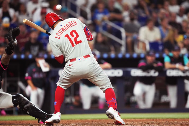 Sep 6, 2025; Miami, Florida, USA;  Philadelphia Phillies designated hitter Kyle Schwarber (12) gets hit by a pitch in the seventh inning at loanDepot Park. Mandatory Credit: Jim Rassol-Imagn Images