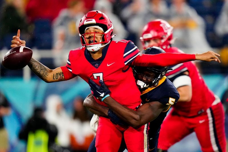 Dec 20, 2022; Boca Raton, Florida, USA; Toledo Rockets linebacker Nate Givhan (5) strip sacks Liberty Flames quarterback Kaidon Salter (7) during the second half in the 2022 Boca Raton Bowl at FAU Stadium. Mandatory Credit: Rich Storry-USA TODAY Sports