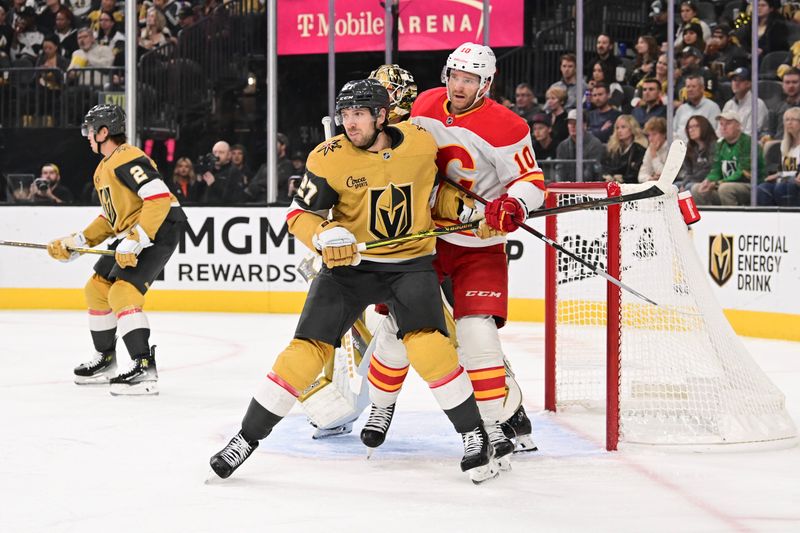 Oct 28, 2024; Las Vegas, Nevada, USA;  Vegas Golden Knights defenseman Shea Theodore (27) battles for position against Calgary Flames center Jonathan Huberdeau (10) in the first period at T-Mobile Arena. Mandatory Credit: Candice Ward-Imagn Images