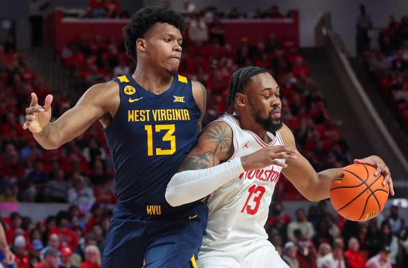 Jan 15, 2025; Houston, Texas, USA; Houston Cougars forward J'Wan Roberts (13) dribbles against West Virginia Mountaineers forward Amani Hansberry (13) in the first half at Fertitta Center. Mandatory Credit: Thomas Shea-Imagn Images