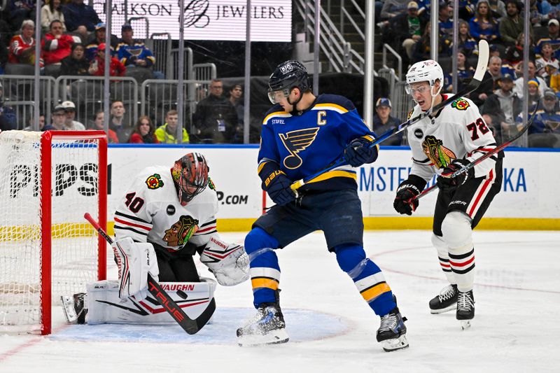 Apr 10, 2024; St. Louis, Missouri, USA;  Chicago Blackhawks goaltender Arvid Soderblom (40) defends the net against St. Louis Blues center Brayden Schenn (10) during the second period at Enterprise Center. Mandatory Credit: Jeff Curry-USA TODAY Sports