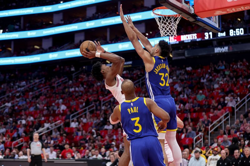 HOUSTON, TEXAS - APRIL 04: Amen Thompson #1 of the Houston Rockets shoots the ball against Trayce Jackson-Davis #32 of the Golden State Warriors in the first half at Toyota Center on April 04, 2024 in Houston, Texas.  NOTE TO USER: User expressly acknowledges and agrees that, by downloading and or using this photograph, User is consenting to the terms and conditions of the Getty Images License Agreement. (Photo by Tim Warner/Getty Images)