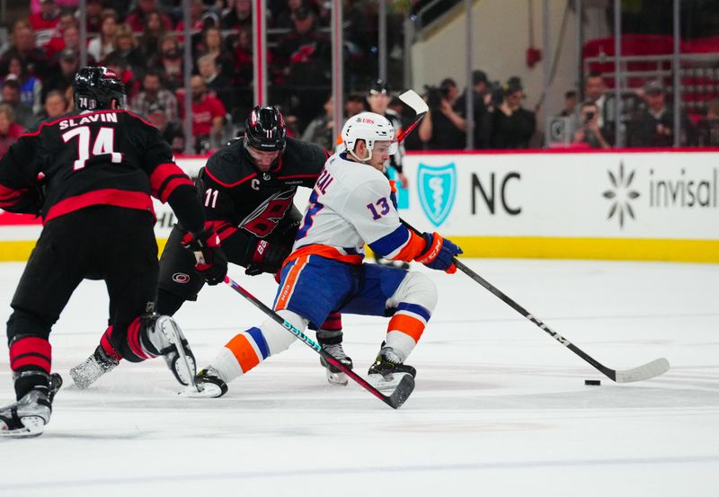 Apr 30, 2024; Raleigh, North Carolina, USA; New York Islanders center Mathew Barzal (13) skates with the puck past Carolina Hurricanes center Jordan Staal (11) during the second period in game five of the first round of the 2024 Stanley Cup Playoffs at PNC Arena. Mandatory Credit: James Guillory-USA TODAY Sports