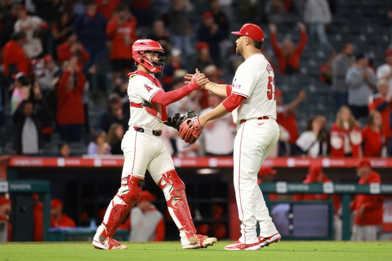 May 15, 2024; Anaheim, California, USA;  Los Angeles Angels catcher Logan O'Hoppe (14) and relief pitcher Carlos Estevez (53) celebrate a victory after defeating the St. Louis Cardinals 7-2 at Angel Stadium. Mandatory Credit: Kiyoshi Mio-USA TODAY Sports