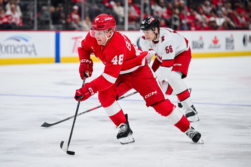 Apr 4, 2025; Detroit, Michigan, USA; Detroit Red Wings right wing Jonatan Berggren (48) brings the puck up ice during the game against the Carolina Hurricanes at Little Caesars Arena. Mandatory Credit: Tim Fuller-Imagn Images